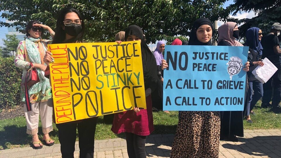 Deux femmes tiennent des pancarties