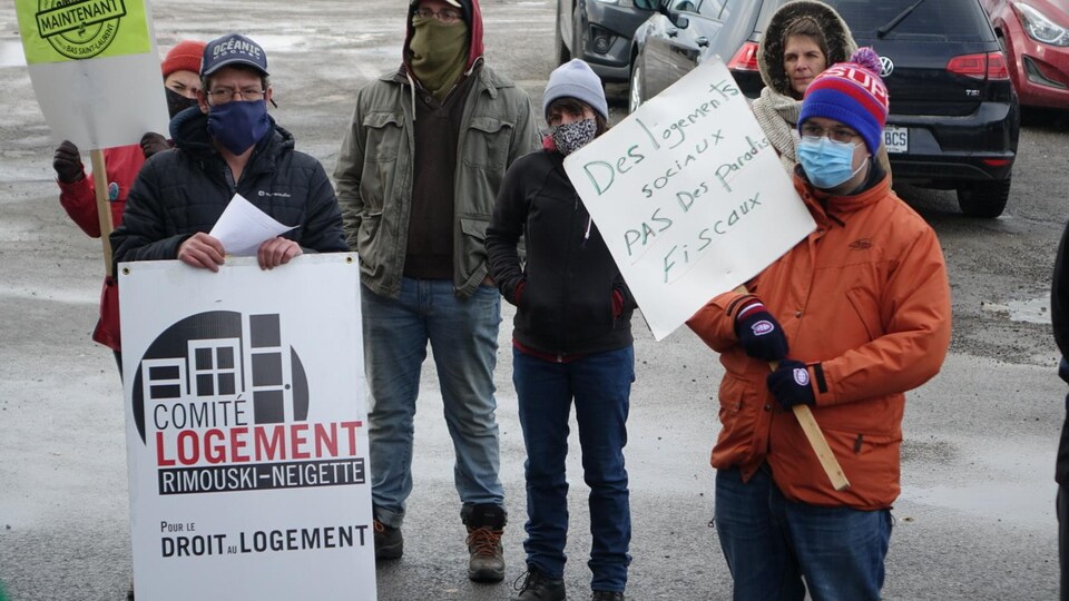 Des hommes et des femmes manifestent pour la construction de logements sociaux.