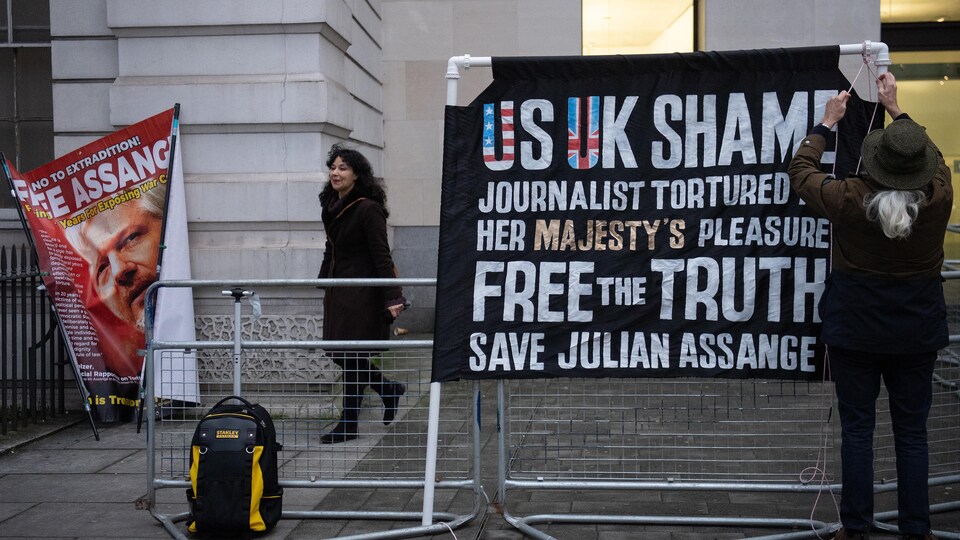 Une banderole et un portrait de Julian Assange.