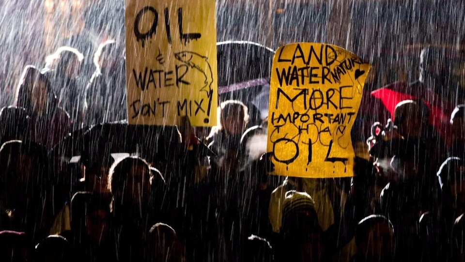 Des manifestants sous la pluie.