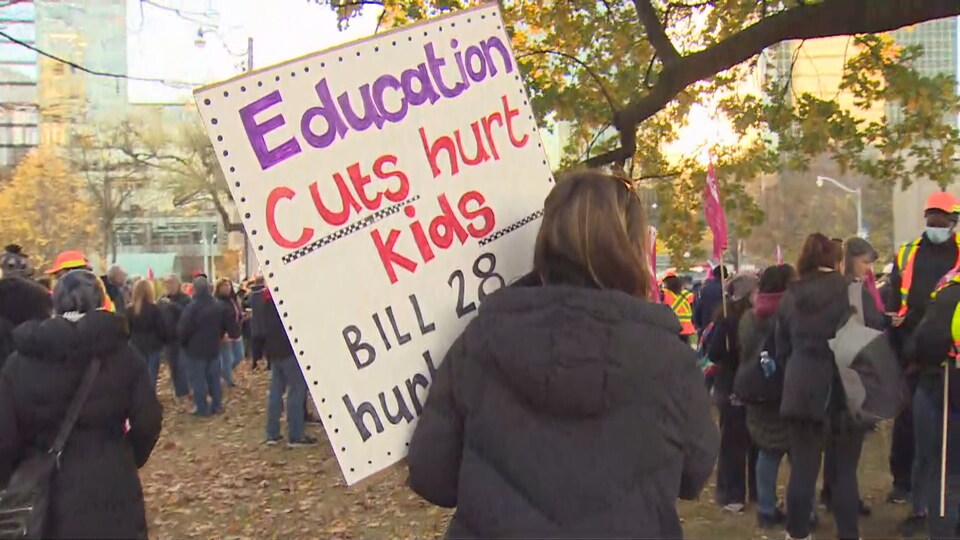 A protester held a placard accusing the government of cutting education.