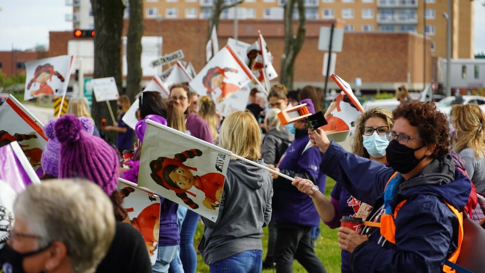 Éducatrices avec des pancartes sur le bord du boulevard René-Lepage à Rimouski.