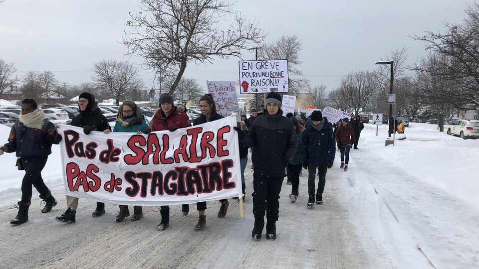Des étudiants tiennent une banderole sur laquelle il est inscrit « Pas de salaire, pas de stagiaire »
