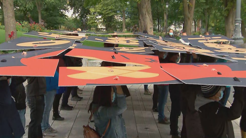 Les manifestants tiennent des pancartes au-dessus de leurs têtes.