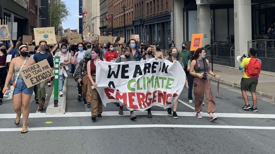 Des manifestantes brandissent une banderole où il est écrit : Nous sommes dans l'urgence climatique.