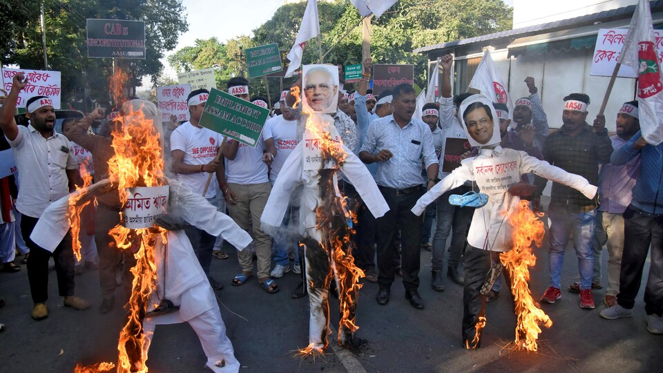 Des militants de l'Union des étudiants de l'Assam (AASU) brûlent des effigies du ministre de l'Intérieur, Amit Shah, du premier ministre, Narendra Modi, et du ministre en chef de l'Assam, Sarbananda Sonowal, lors d'une manifestation contre la nouvelle loi sur la citoyenneté.