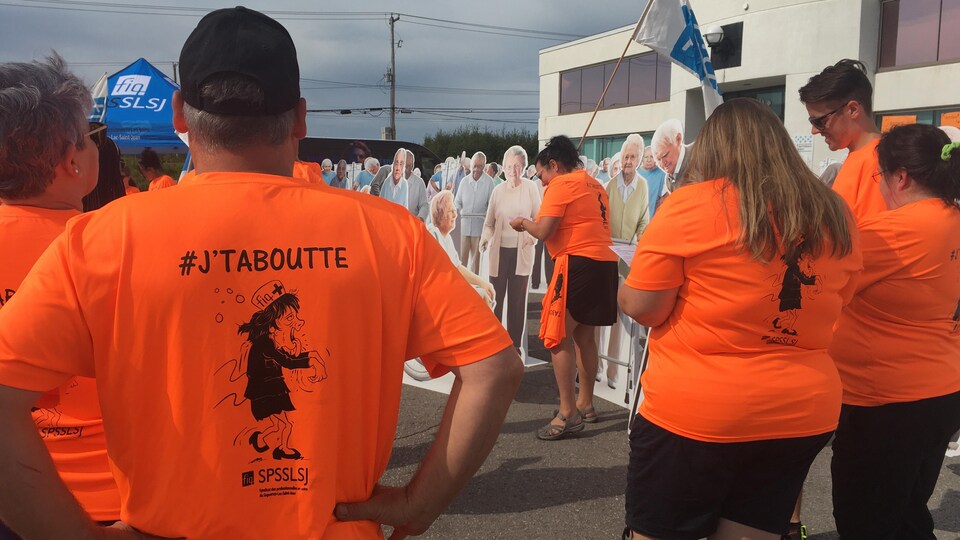 Des manifestants sont rassemblés devant une bâtisse.