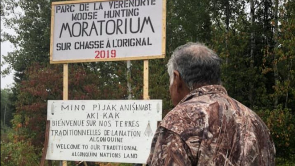 Un chasseur regarde des pancartes.