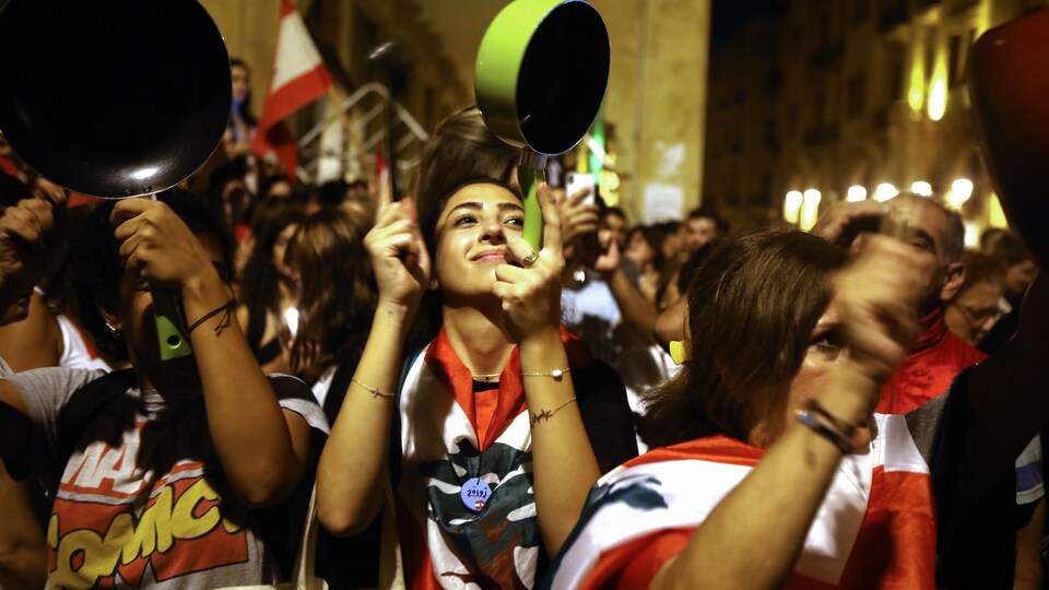 Des manifestantes tapant sur des casseroles lors d'une marche dans le centre-ville de Beyrouth.
