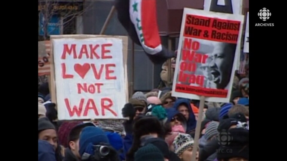 Manifestants rassemblés sur la 1re Avenue de New York. Sur une affiche, le slogan : «Make love not war».