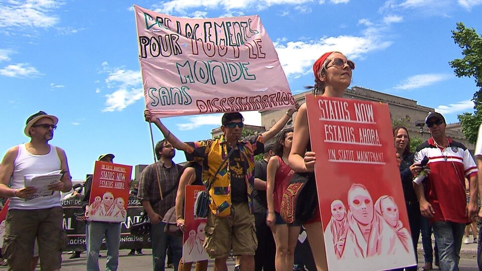 Des manifestants à Montréal réclamant la régularisation du statut de tous les migrants.