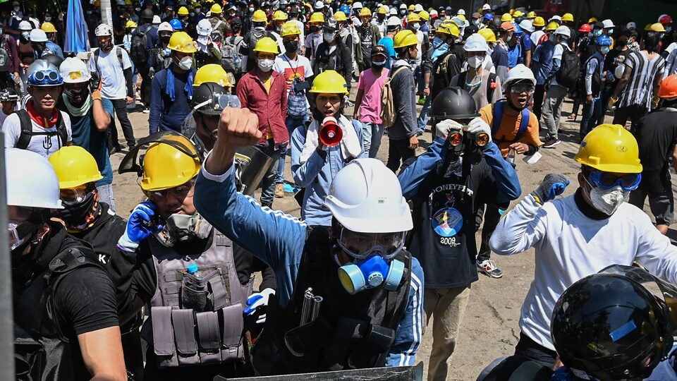 Des centaines de manifestants avec des masques et des casques.