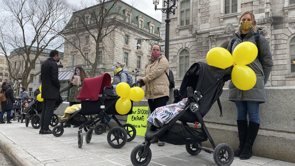 Des parents avec des masques et des poussettes.