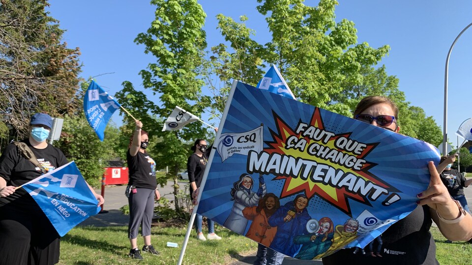 Une femme tient une drapeau.