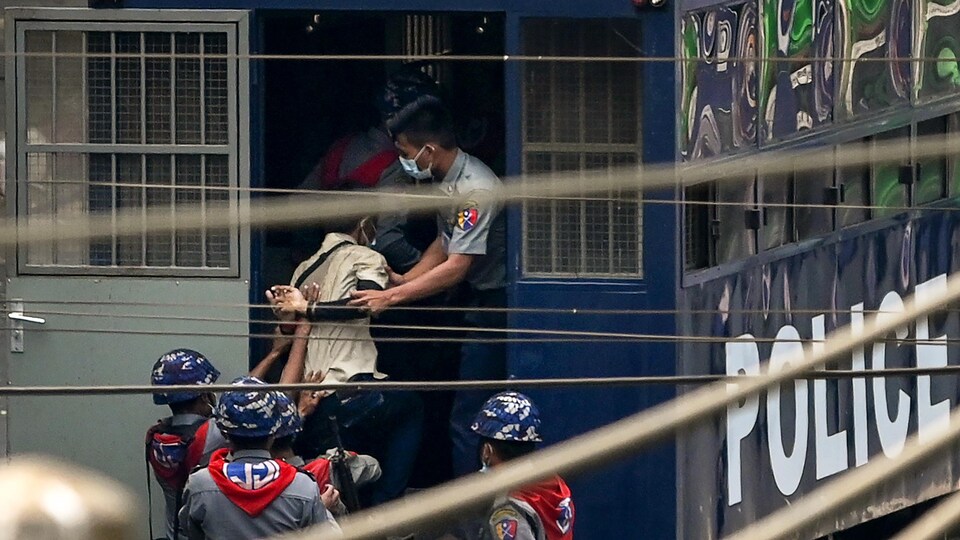 La police arrête un manifestant et l’embarque à Rangoon.