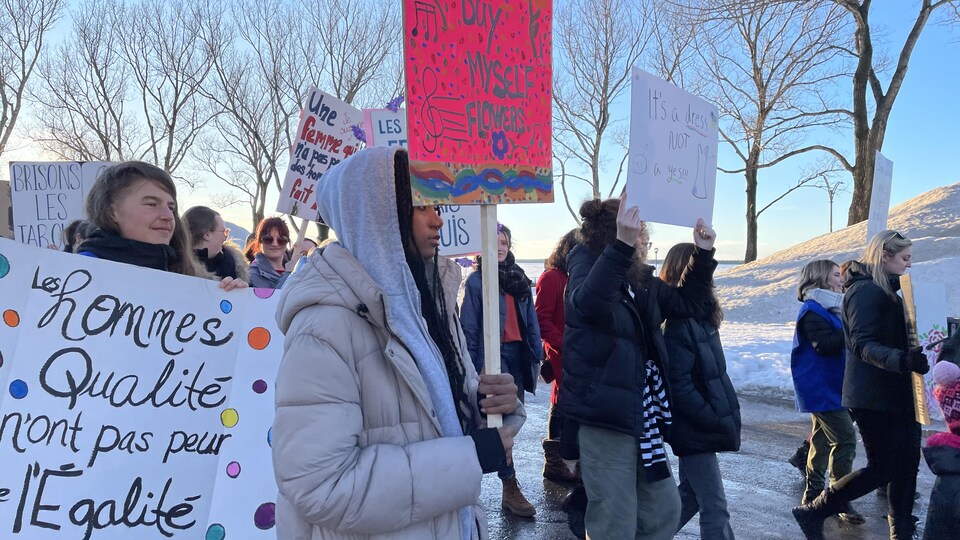 Des manifestantes avec des pancartes affichant différents slogans féministes. 