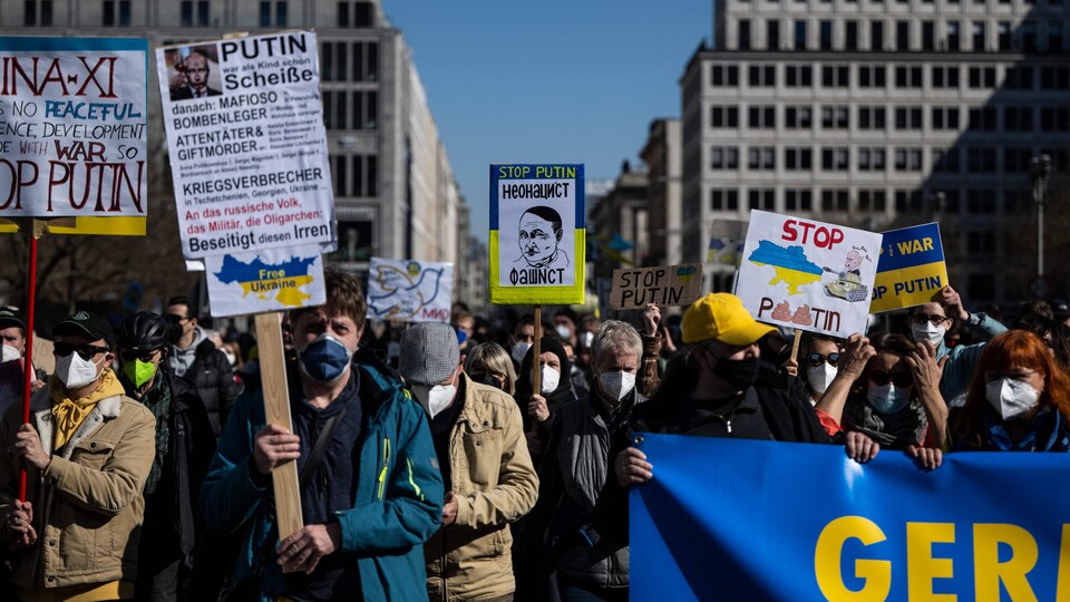 Des manifestants brandissent des pancartes en signe de soutien à l'Ukraine.