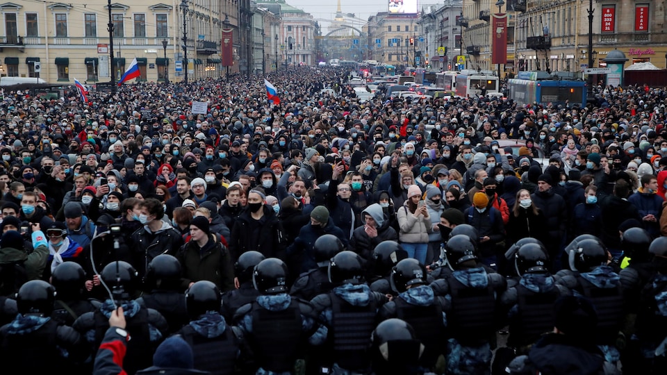 Des agents des forces de l'ordre devant les participants d'un rassemblement à Saint-Pétersbourg. 