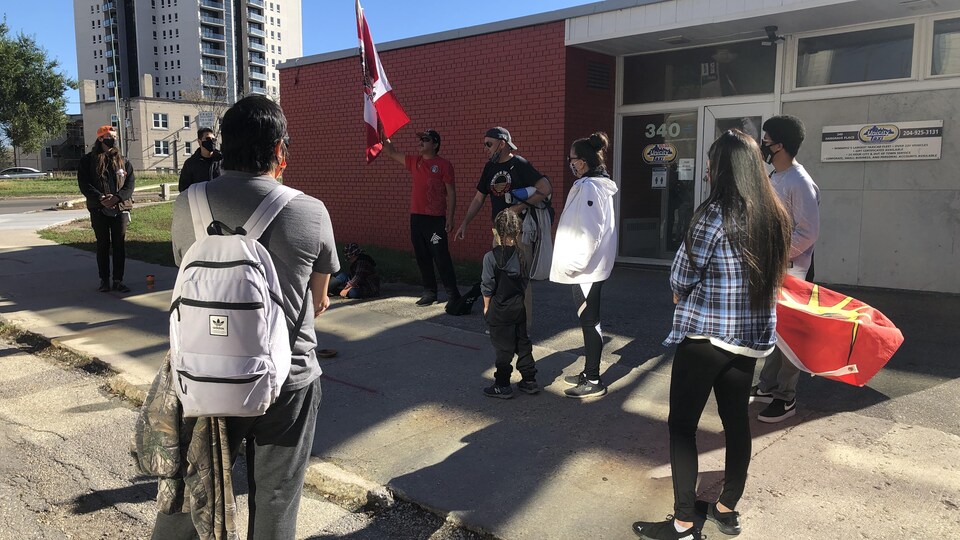 10 personnes sont devant les bureaux de Unicity Taxi.