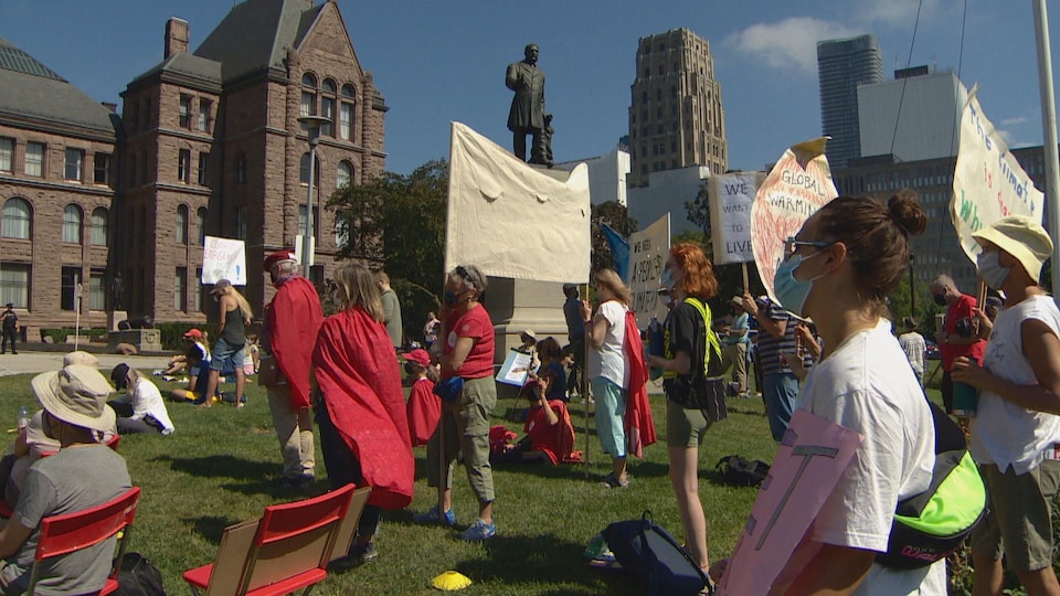 Des manifestants debout avec des pancartes.