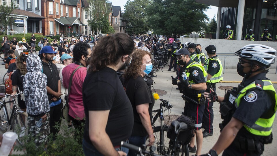 Des policiers forment une rangée pour bloquer des manifestants.