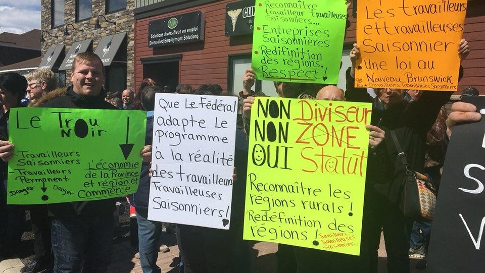 Des manifestants avec des pancartes.