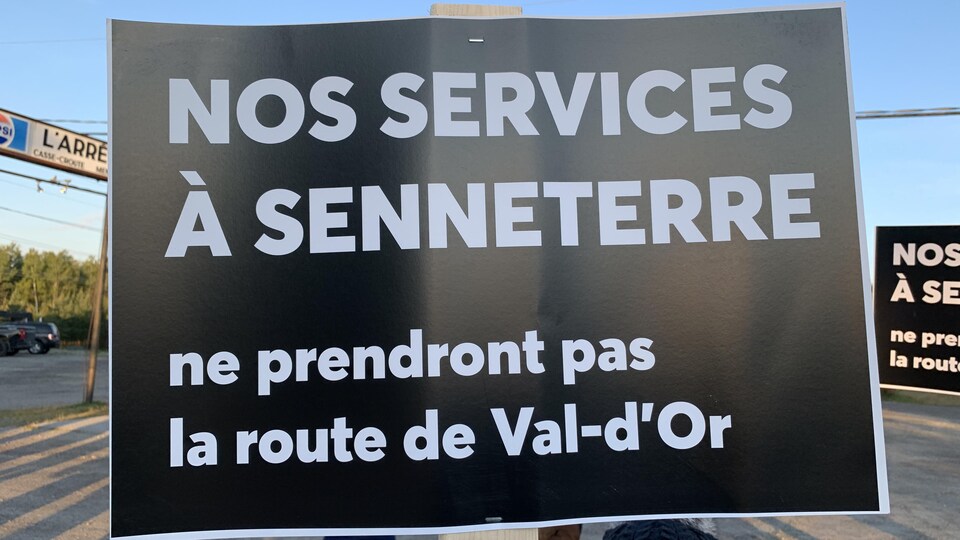 Une affiche de manifestant indique : « Nos services à Senneterre ne prendront pas la route de Val-d'Or ».
