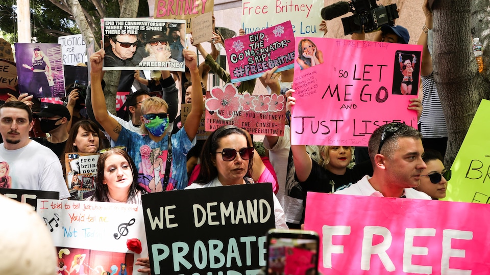 À l'extérieur, des personnes brandissent des pancartes avec des messages d'appui à la chanteuse.