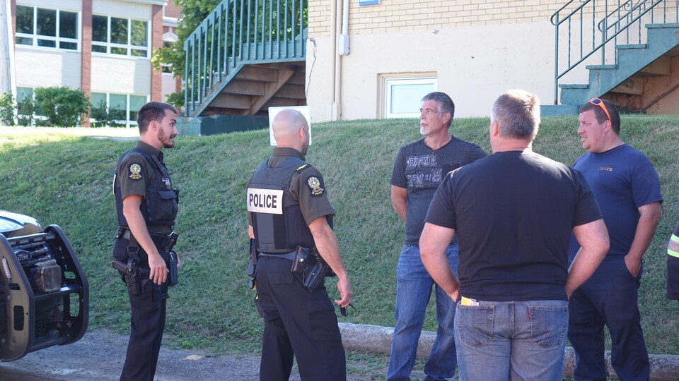 Des policiers de la Sûreté du Québec interpellent des camionneurs.