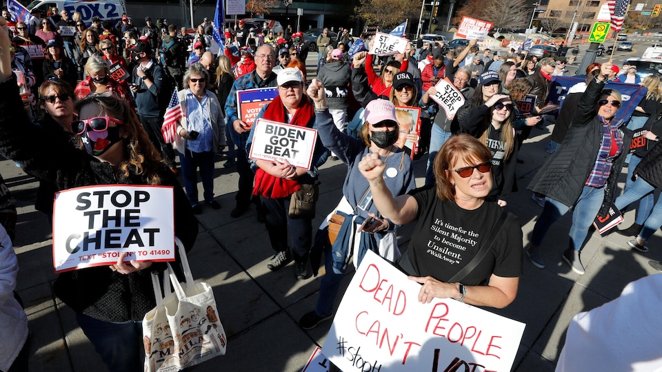 Des dizaines de personnes manifestent avec des pancartes sur lesquelles on peut lire « Arrêtez la tricherie », « Biden s'est fait battre » ou « Les morts ne peuvent pas voter ».