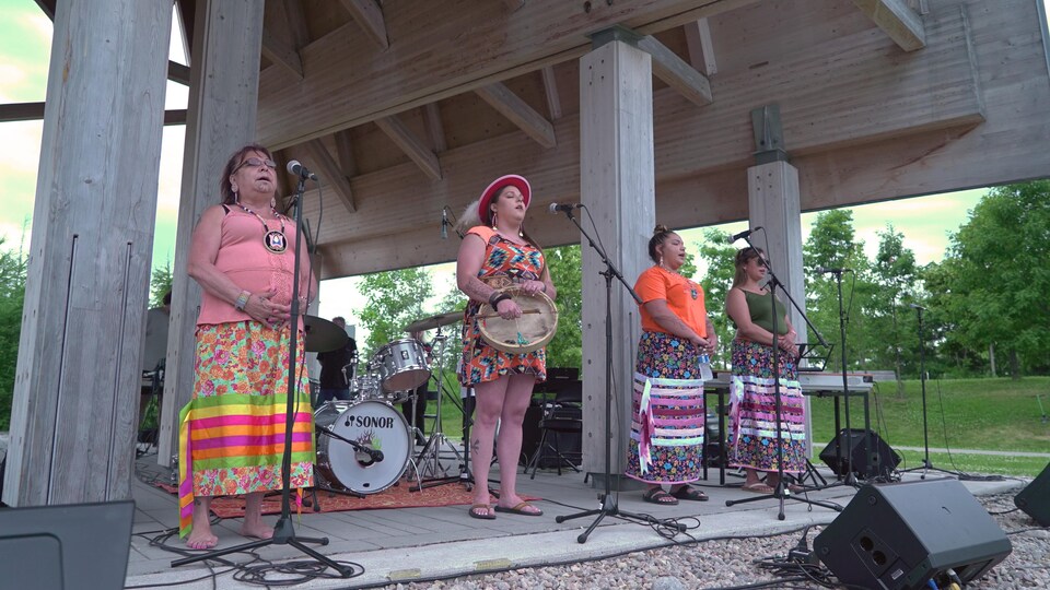 Quatre chanteuses Manitou Mkwa chantent à la Place de l'Ontario.