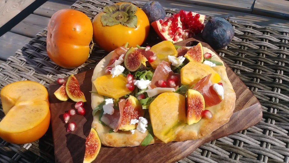 Une pizza sur une plaque de bois.