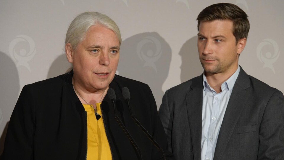 Manon Massé et Gabriel Nadeau-Dubois sont derrière un lutrin et discutent avec la presse. 