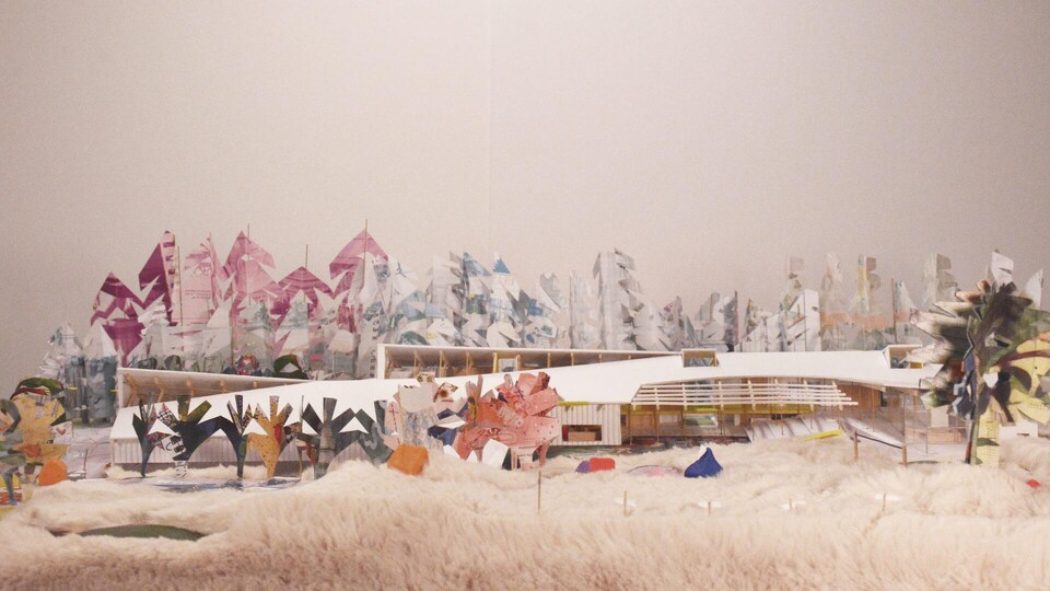 Maquette d'un bâtiment entouré d'arbres en papier.