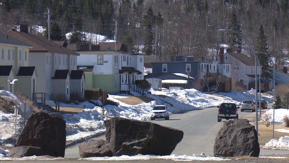 Des voitures sont garées le long d'une rue résidentielle en hiver.