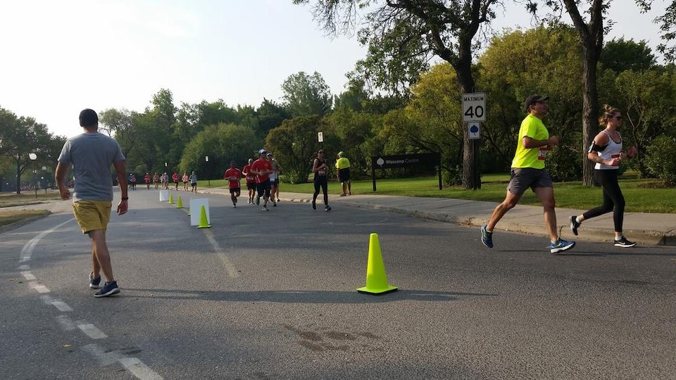 Des coureurs sur une route en bordure d'un parc.