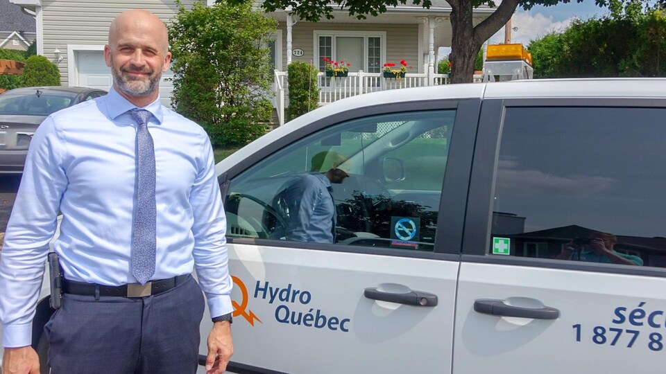 Marc Desaulniers, chef, intervention, vol d'électricité à Hydro-Québec pose à côté d'une voiture de la société d'État