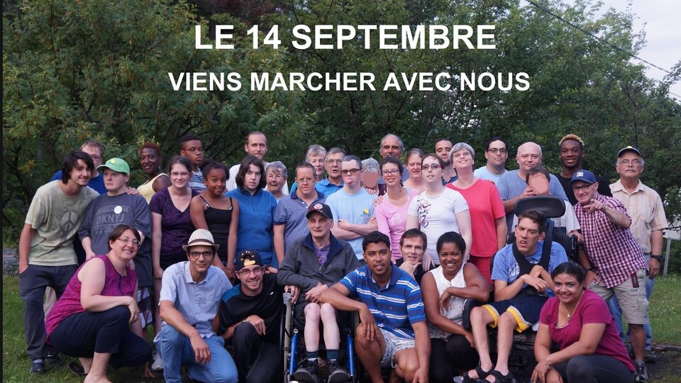 Un groupe de personnes est rassemblé dehors et sourit.