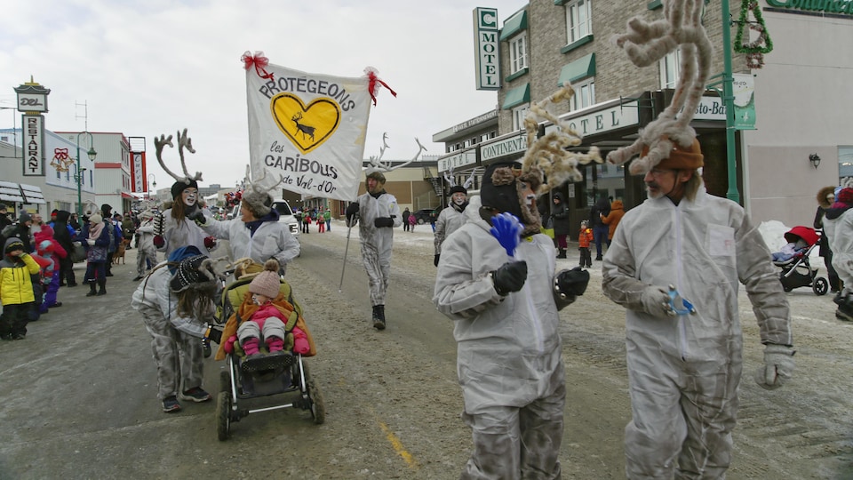 Des gens déguisés marchent dans un défilé en hiver