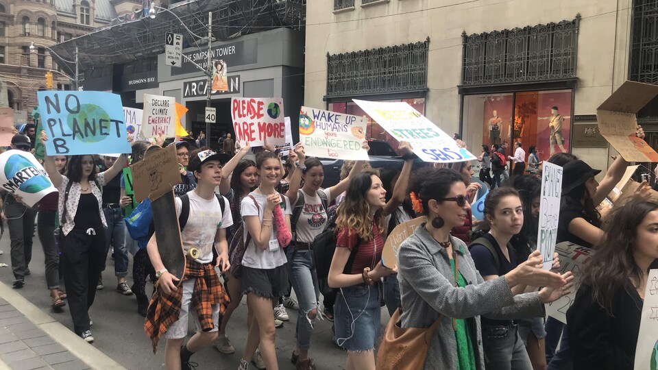 Des jeunes qui manifestent, brandissant des pancartes.
