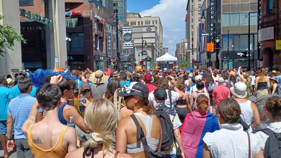 Des centaines de personnes sont rassemblées au milieu de la rue Sainte-Catherine à Montréal.