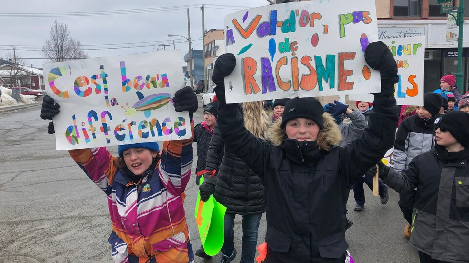 Des enfants participent à une marche avec une affiche «Val-d'Or pas de racisme».