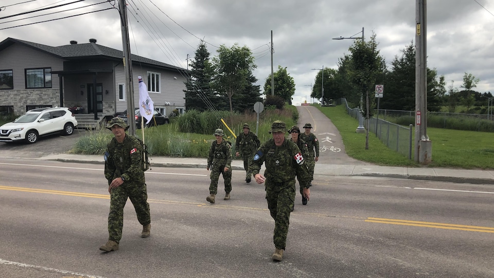 Six militaires traversent une rue de Saguenay.