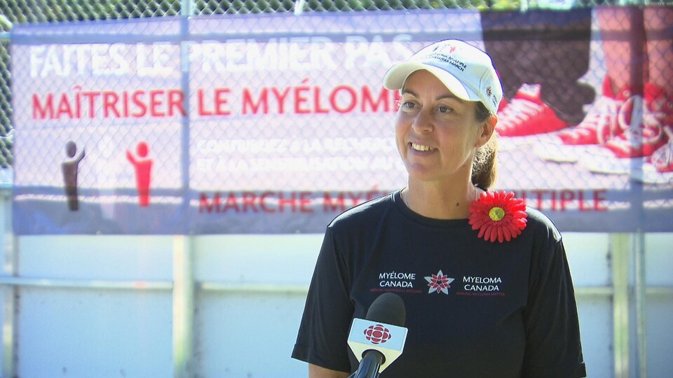Vénus Bélanger, participante de la marche, souriante devant le micro de Radio-Canada.