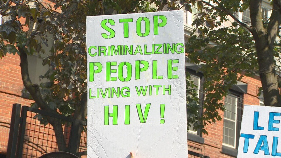Des panneaux appellent à lutter contre la stigmatisation et l'exclusion des personnes atteintes du VIH lors de la 29e Marche action sida à Toronto.