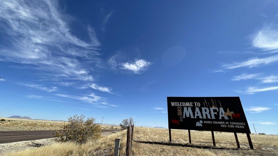 A sign announcing Marfa, on a desert road.