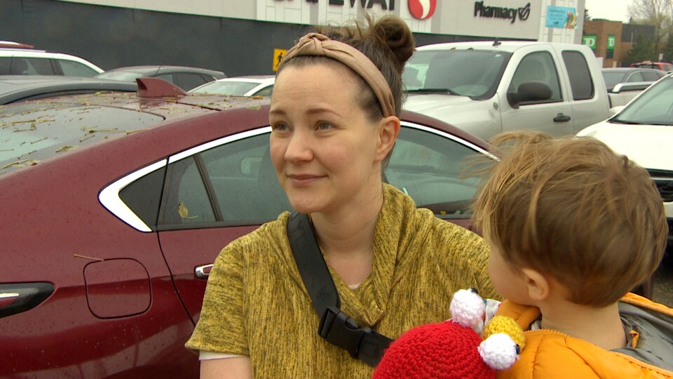 Margaret Eve Mackinnon, avec un enfant dans ses bras, devant le centre commercial Tuxedo, le 24 octobre 2022. 