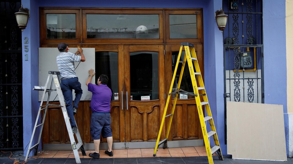 Préparation d'une façade d'un commerce à San Juan à Porto Rico en prévision du passage de l'ouragan Maria.