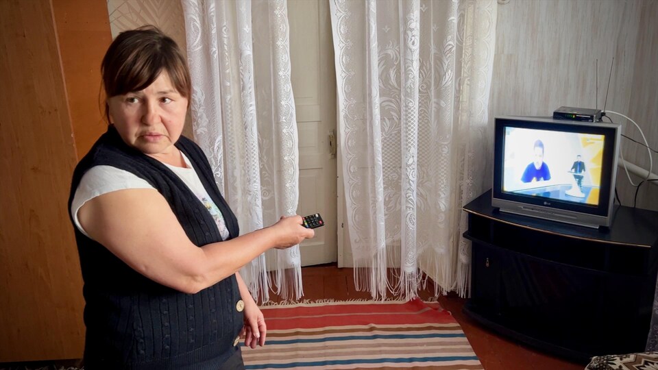 Une femme devant un poste de télévision.