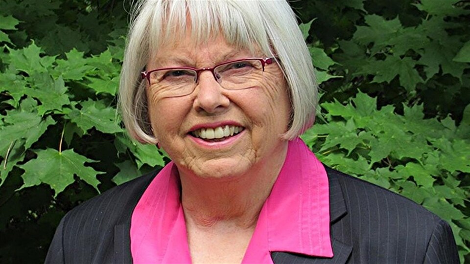 Marianne Wilkinson pose devant un mur végétal.